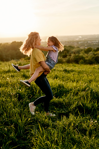 Caucasian woman have fun with daughter at the meadow