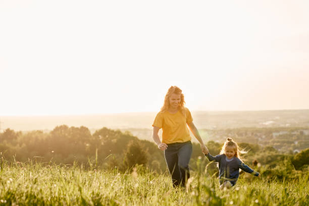 istock Caucasian mom with daughter running at the meadow 1404355731
