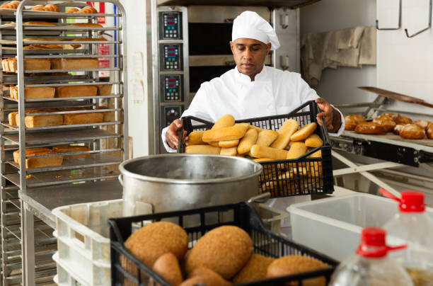 istock Male baker holding crate with baked bread 1404355794