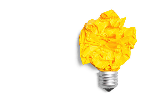 Bulb base and crumpled paper ball shaped into a glowing lightbulb isolated on white. How to get writing ideas.