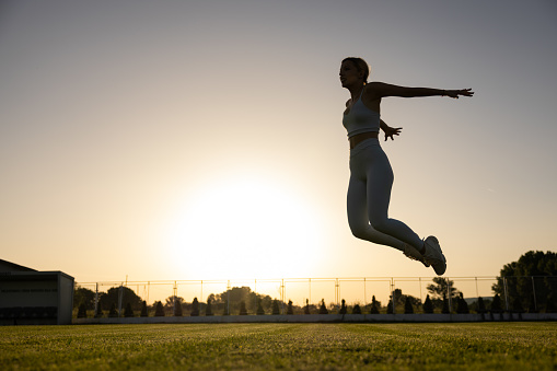 Caucasian young woman excercise on the sports court during sunset