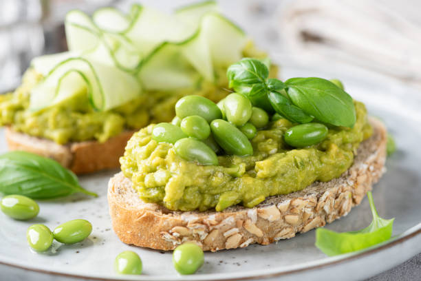 istock Fresh green avocado toasts with edamame beans and cucumber toppings 1404363078