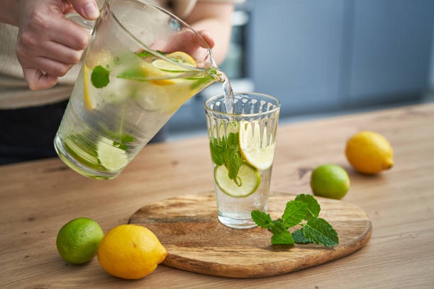 istock Unrecognizable person pouring lemonade from jug into the glass 1404365520