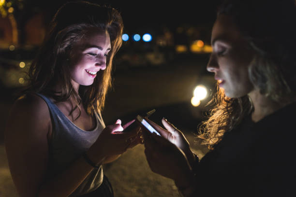 istock Millennials happy women with mobile phones at night 1404366309