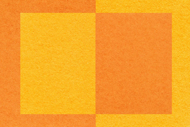 istock Texture of yellow and orange paper background with geometric pattern, macro. Structure of craft cardboard with frame. 1404367352
