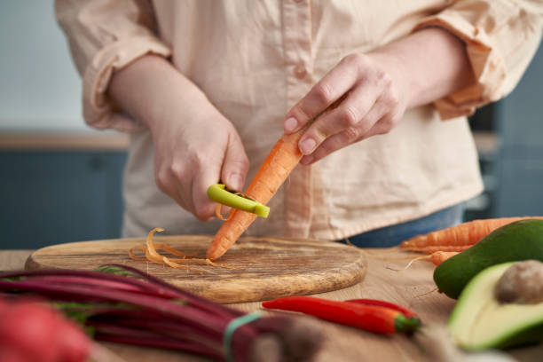 istock Close up of woman's hands peeling carrots 1404367832