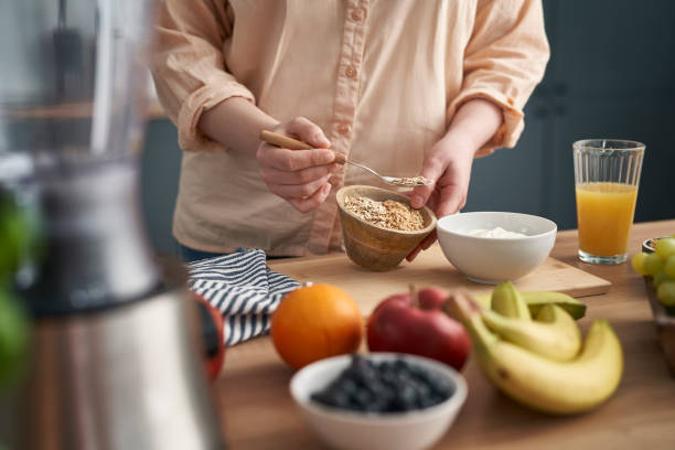 istock Woman adding muesli into the bowl with yogurt 1404369057
