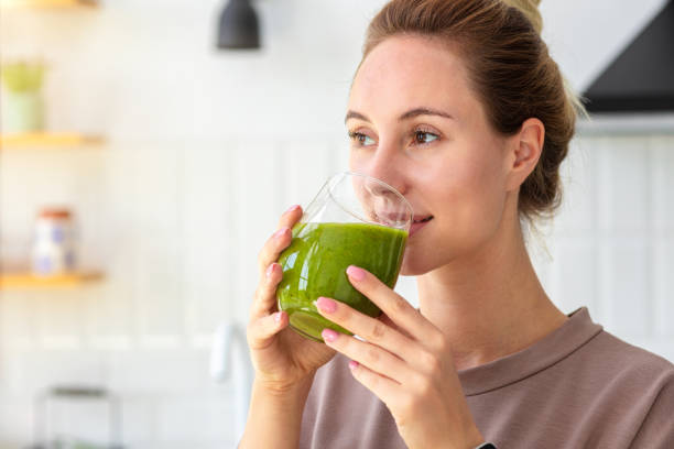 Healthy lifestyle, diet, weight loss concept. Portrait of woman drinking green smoothie close-up. Healthy food, breakfast. Vegetarian, vegan food stock photo