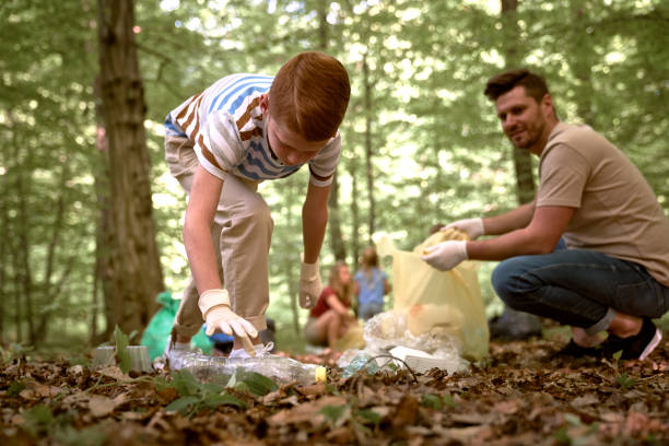 Confident brother and sister help their neighbors pick up trash in their community park.