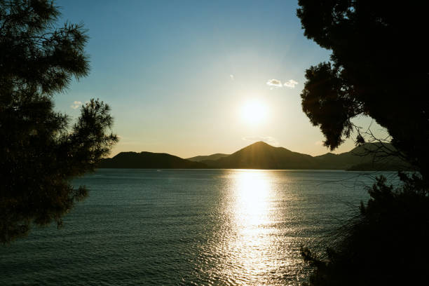 istock Sunset over a mountain range by the sea, view from the forest 1404370392