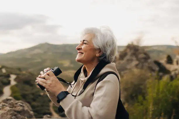 Photo of Senior woman looking at the view from a hilltop
