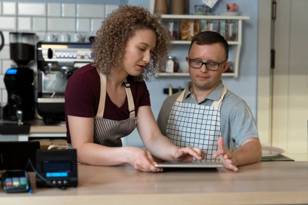 istock Caucasian man with down syndrome learning how to take orders on digital tablet 1404377928