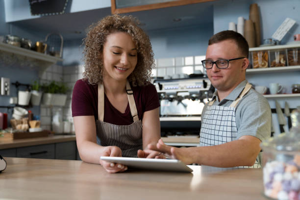 istock Caucasian man with down syndrome learning how to take orders on digital tablet 1404377978