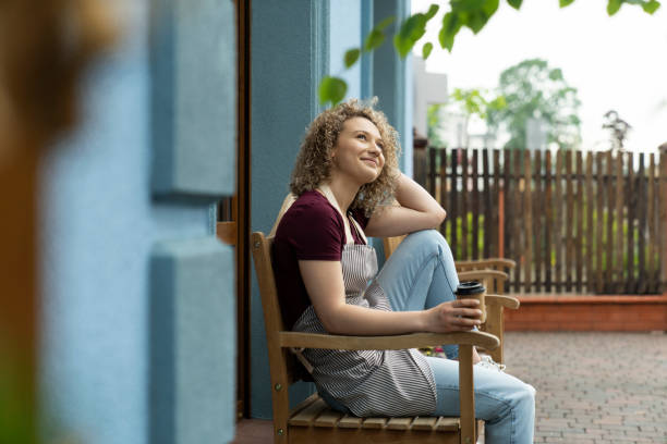 istock Caucasian waitress having break with coffee outdoors 1404379383