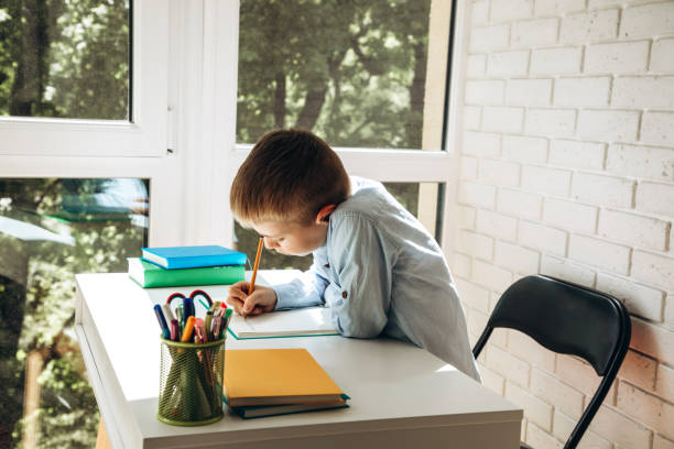 istock A schoolboy writes numbers in a notebook at the desk. Back to school concept 1404382103
