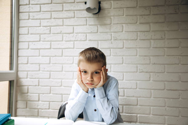 istock A schoolboy 6-7 years old in a blue shirt thought while studying at his desk and thinking 1404382108