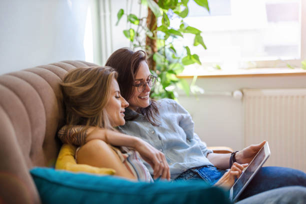 istock Lesbian couple sitting on a sofa and using a tablet 1404382340