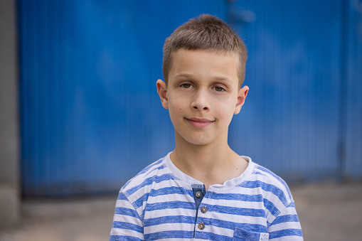 Portrait of cheerful Caucasian boy in front of the blue background