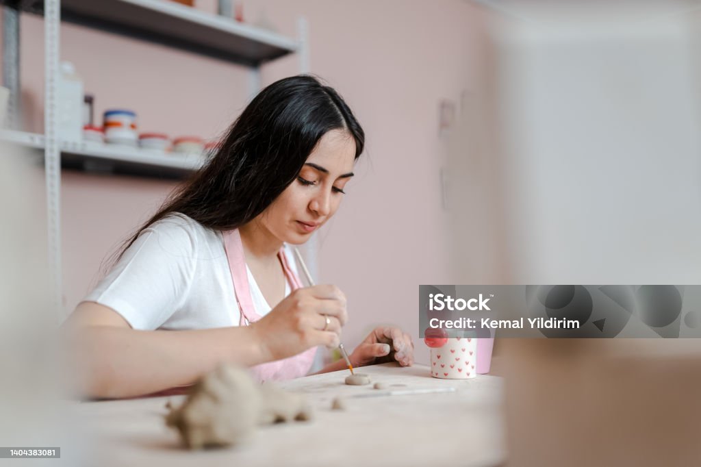 Beautiful woman kneading clay in workshop Pottery Stock Photo