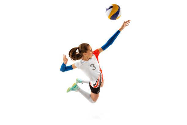 Aerial view of professional volleyball player in sports uniform in motion with ball isolated on white background. Action, sport, healthy lifestyle, team, fitness concept stock photo