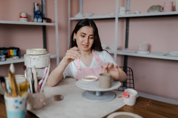 istock Beautiful woman kneading clay in workshop 1404384851