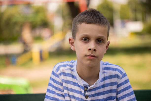istock Caucasian boy with contented emotion, sitting on the park bench 1404385323