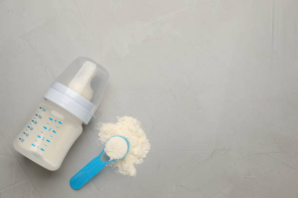 istock Feeding bottle with infant formula, scoop of powder and space for text on grey table, flat lay. Baby milk 1404391851
