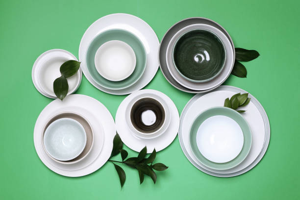 istock Different dishware and leaves on green background, flat lay 1404392444
