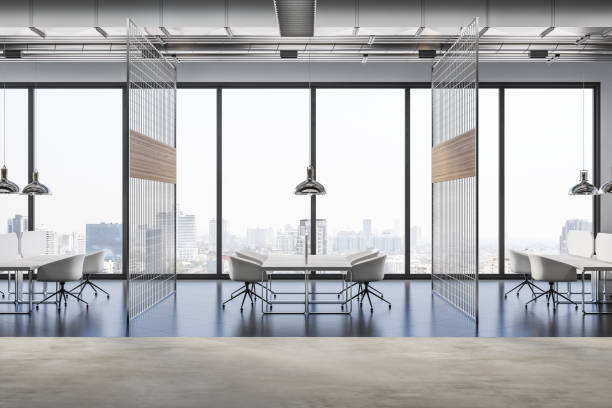istock Side view on white modern design workspaces divided by lattice partitions in coworking office with glossy and concrete floor and city view from panoramic window. 3D rendering 1404396747