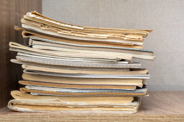 istock Stacked in a row old vintage study notepads on wooden shelf 1404398655
