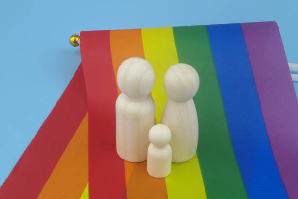 Female and male people figures with child on LGBT flag. stock photo