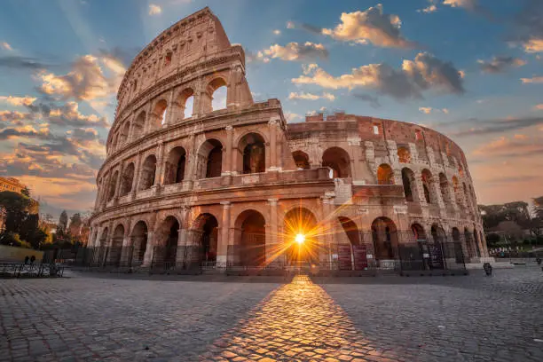 Rome, Italy at the Colosseum Amphitheater with the sunrise through the entranceway.