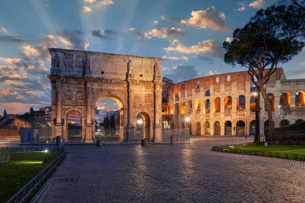 Rome, Italy at the Arch of Constantine and the ancient Roman Colosseum at twilight.