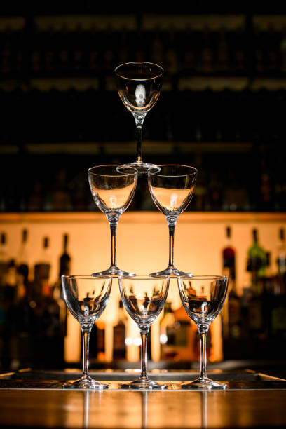 istock Close-up view on pyramid of empty glasses on bar counter. Blurred background 1404403494