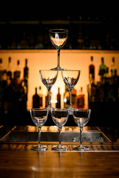 istock front view on pyramid of empty glasses on bar counter. Blurred background 1404403555