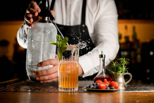 istock beautiful glass with with splashing cocktail in which bartender adds liquid from siphon 1404404063