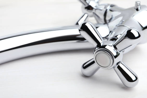 istock Double handle water tap on white wooden table, closeup 1404404464