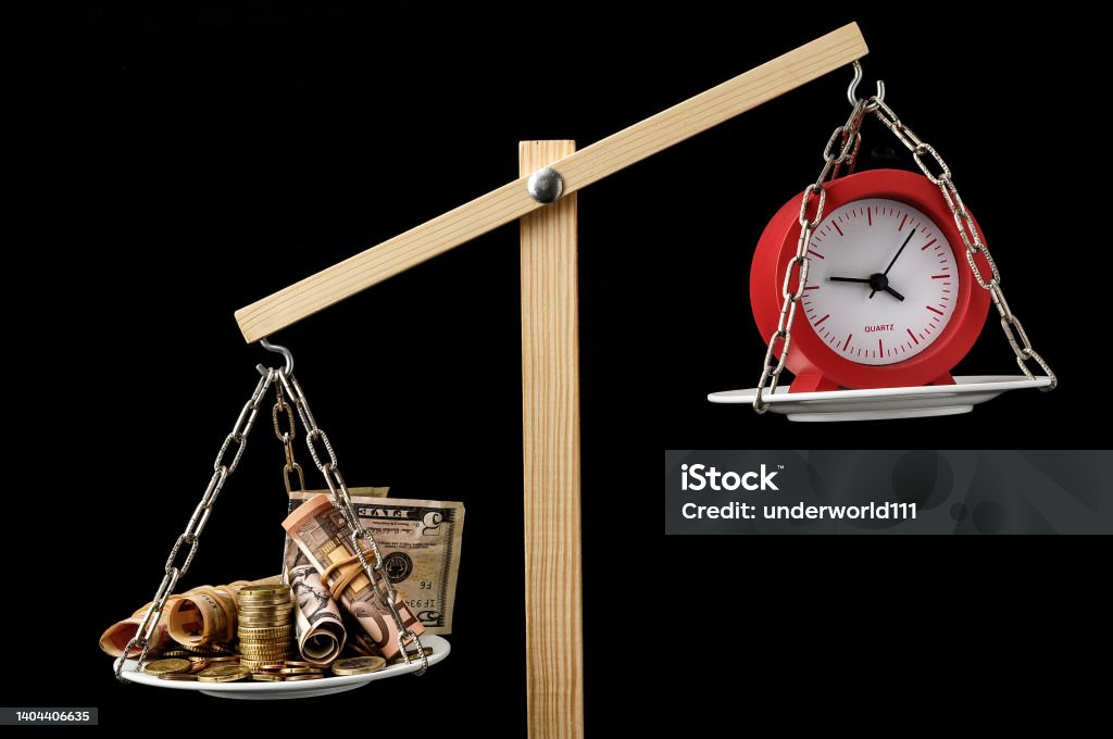 Clock and Currency Time is Money Concept Time is Money Concept Clock and Currency on a Two Pan Balance Balance Stock Photo