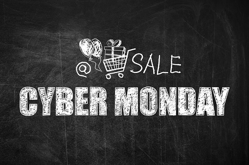 Text Cyber Monday Sale and picture of shopping cart on blackboard