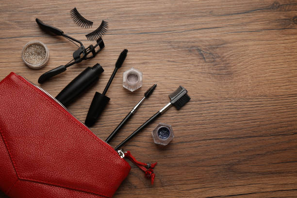 istock Flat lay composition with eyelash curler, makeup products and accessories on wooden table. Space for text 1404414801