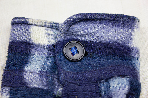 The Buttons on the old vintage woven sleeve. Button on the sleeve of a vintage blue jacket.Vintage sweatshirt design.