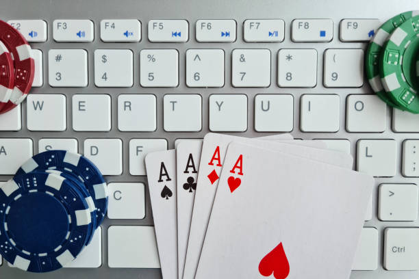 istock Playing cards casino chips and computer keyboard closeup 1404415364