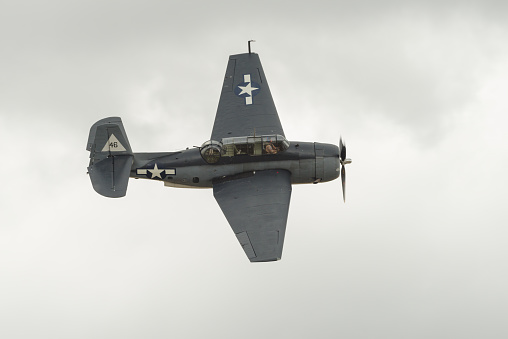 Biplane landing with cloudy sky on the background.