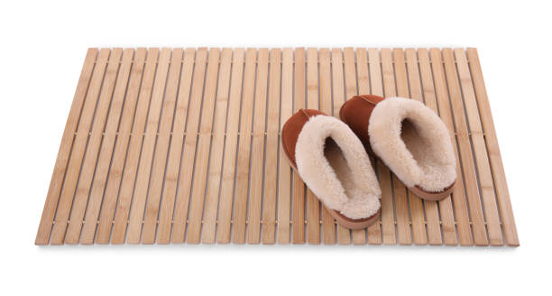 istock Bamboo rug with soft slippers isolated on white. Bath accessory 1404416326