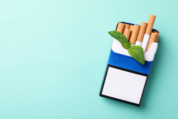 pack of menthol cigarettes and mint on turquoise background, top view. space for text - detrimental imagens e fotografias de stock