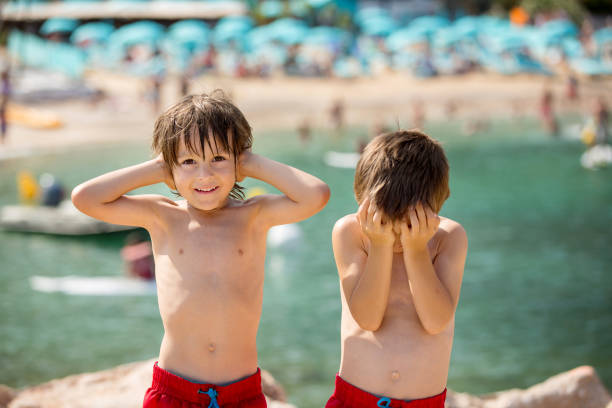 istock Two children on the beach, boys, playing and making funny faces 1404420866