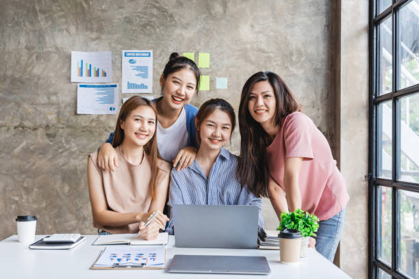 istock Asian lady successful business team posing for presentation of work while looking at camera in a coworking space. 1404421136