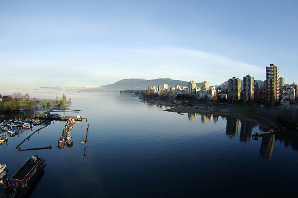 Vancouver, BC Views of English Bay and North Shore Mountains taken from Burrard Bridge in early morning light. beach english bay vancouver skyline stock pictures, royalty-free photos & images