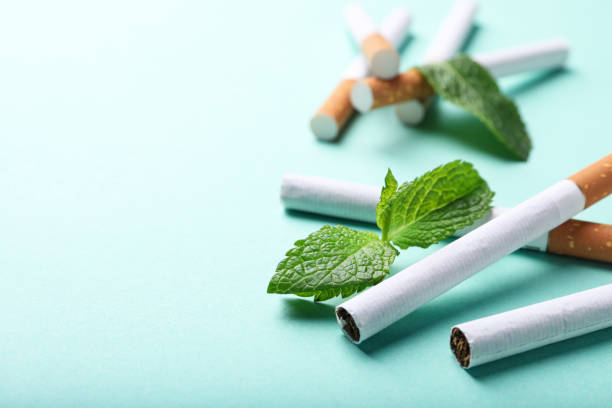 menthol cigarettes and mint on turquoise background, closeup. space for text - detrimental imagens e fotografias de stock