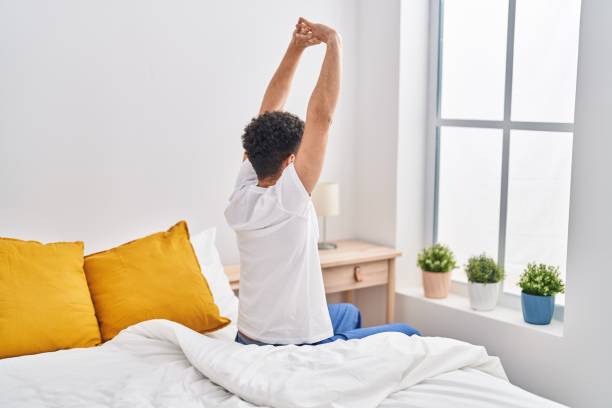 istock Young arab man waking up stretching arms at bedroom 1404422770